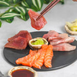 Assorted sashimi slices platter on black tray